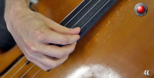 Man Plays Strings on a Cello Close Up