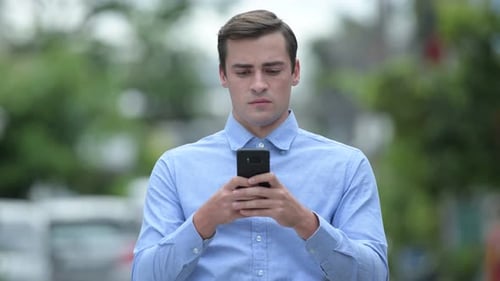 Young Adult Using Phone in Urban Setting