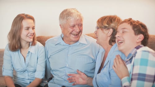 Smiling Family Laughing Together on the Couch