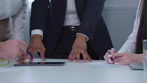 Team Discussing Data on Tablet in Office