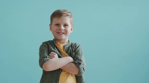 Smiling Boy Crosses Arms in Studio