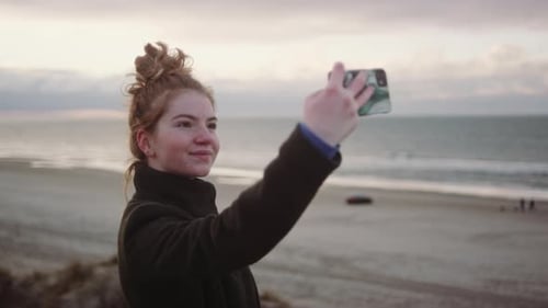 Redheaded Girl Taking Selfie At Beach