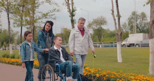 Family Stroll With Wheelchair in Sunny Park Setting