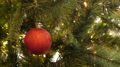 Fairy-lights and shiny Christmas ornament close-up 4K 2160p 30fps UltraHD footage - Red bauble with