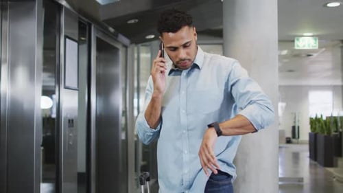 Video of biracial businessman using smartphone and checking watch