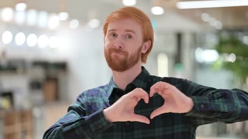 Young Adult Makes Heart With Hands
