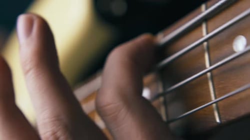 Close Up of Hand Playing Stringed Instrument