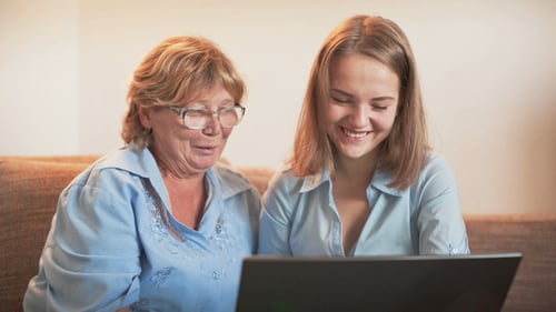 Young Woman Helping Senior Woman with Laptop