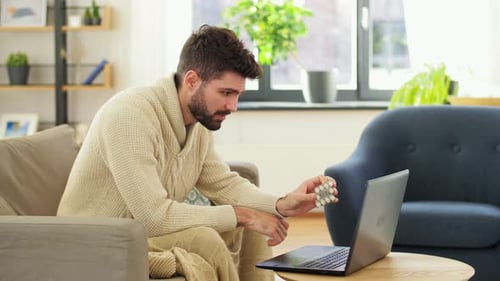Man Holding Pills During Telehealth Appointment