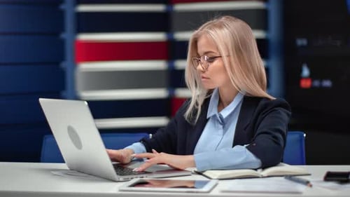 Confident Business Lady Working Use Laptop Sitting Desk with Paper Document at Innovation Office