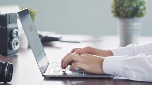 Hands Typing on Laptop at Office Desk