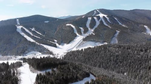 Aerial Ski Slopes with Skiers and Ski Lifts on Ski Resort. Snowy Mountain Forest