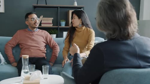 Familia infeliz que grita discutiendo problemas de relación con un consejero durante la terapia de pareja