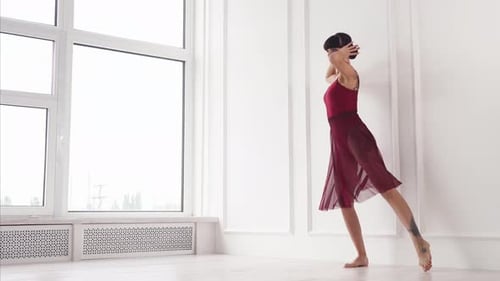 Modern Ballerina Is Dancing Passionately Near White Wall in a Hall