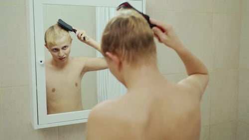 Handsome Man Looking Face In Front Of Mirror. Sexy Manat Bathroom Comb Hair