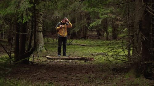 A Man with a Backpack Travels Through a Beautiful Forest