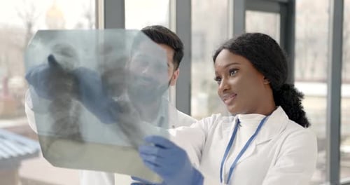 Doctor and Coworker Standing and Looking at Xrays in Clinic