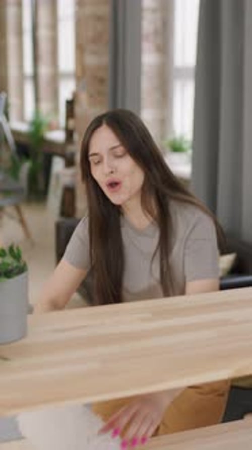 Young Woman Sings with Feather Duster at Table