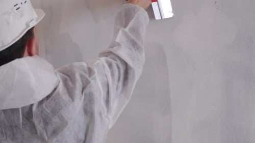 Construction Worker Applying Plaster to Interior Wall