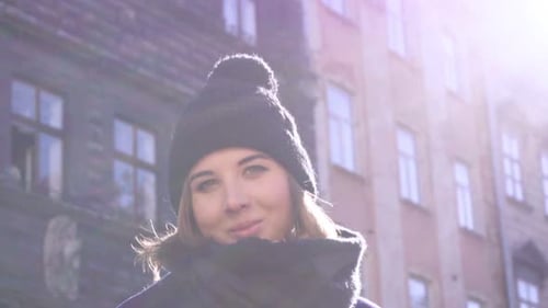 Woman in Hat and Scarf on City Street