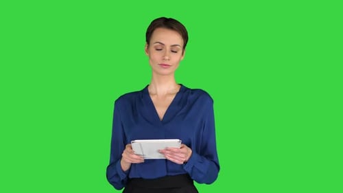 Businesswoman Isolated Swiping the Tablet Presenting Something on a Green Screen, Chroma Key.