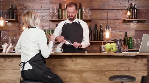 Waitress at a Bar Counter Passionately Telling a Story To the Bartender