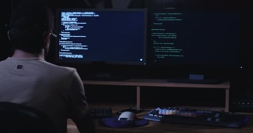 Computerhacker sitzt in einem dunklen Raum und hackt Sicherheitssysteme
