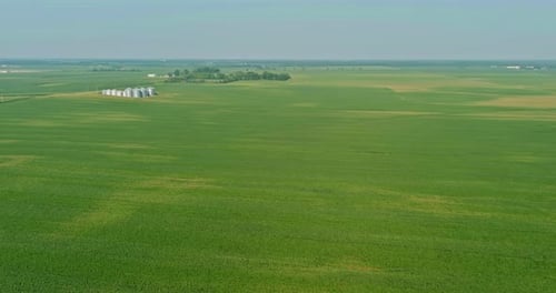 Aerial View of Vast Green Farmland and Silos