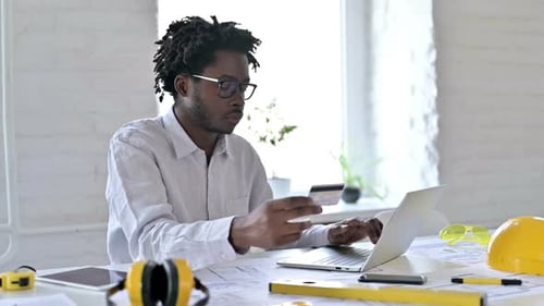 Young Adult Working On Computer With Credit Card