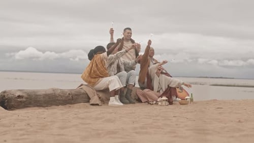 Friends Holding Bengal Lights on Beach