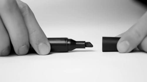 Hands Replace Cap on Black Marker