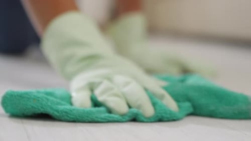 Female Hands in Gloves Scrubbing Floor