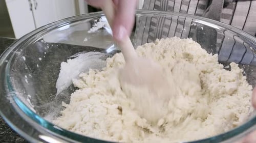 Hands Mixing Dough in Bowl with Spatula