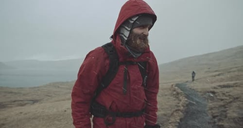 Two people walk together in the mountains during extreme weather
