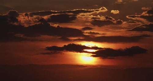 Orangefarbener Sonnenuntergang auf einem Hintergrund Aus Wolken. Nahaufnahme Timelapse