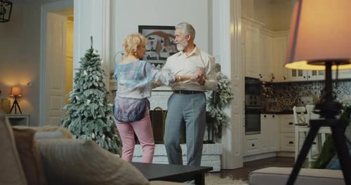 Senior Couple Dancing Near Decorated Christmas Tree
