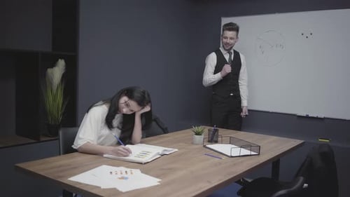 Jovem está dançando perto do conselho do escritório tentando animar sua colega
