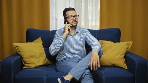Man Talking on Phone While Relaxing on Couch