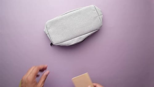Top View of Young Man Putting Office Stationary in His Bag