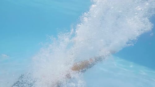 Male Swimmer Dive on Blue Water in Swimming Pool at Start Slow Motion. Young Man Jumping in