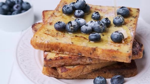 Cooking french toast with blueberries and maple syrup for breakfast.