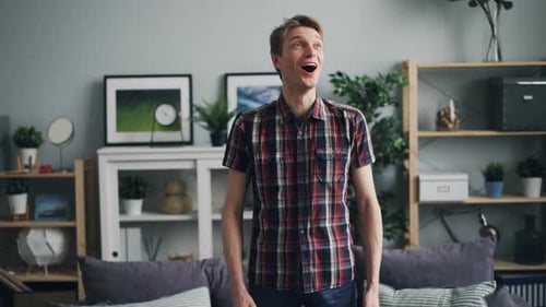 Man Reacts with Surprise and Delight Indoors