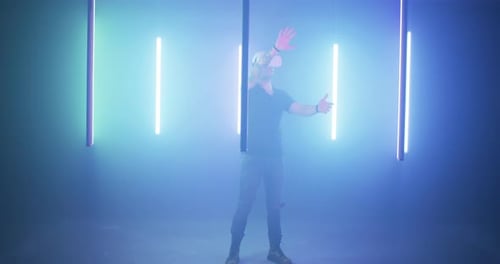 Guy in VR Glasses Amidst Colorful Lamps