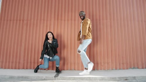Energetic Man and Woman Dancing Outside