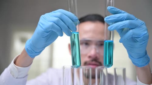 Scientist Examining Test Tube with Blue Liquid