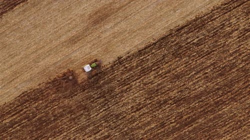 Aerial View Tractor Working on Field After Harvest