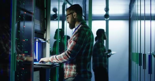 Bärtiger IT-Ingenieur nutzt Laptop im Serverraum