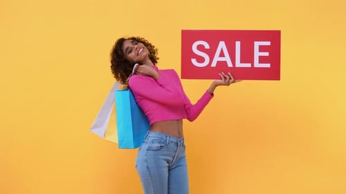 Woman with Sale Sign and Shopping Bags