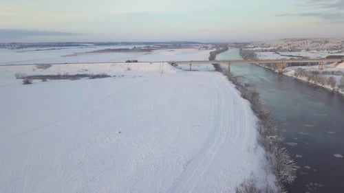 drone shooting of a river against the background of a forest and a bridge,