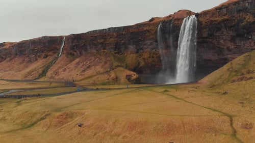Panorama of dry field with waterfall